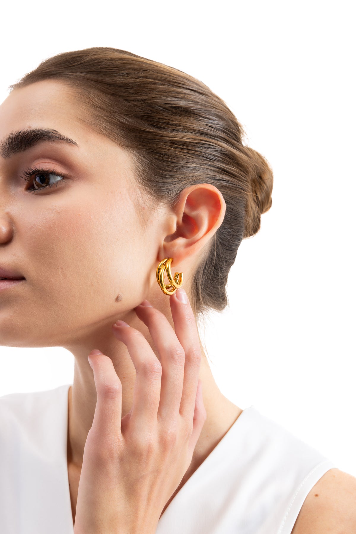 Taviel Creolen Edelstahl 18K vergoldet – Portraitaufnahme, Modell berührt Ohr, Creolen im klassischen dreifach-Design