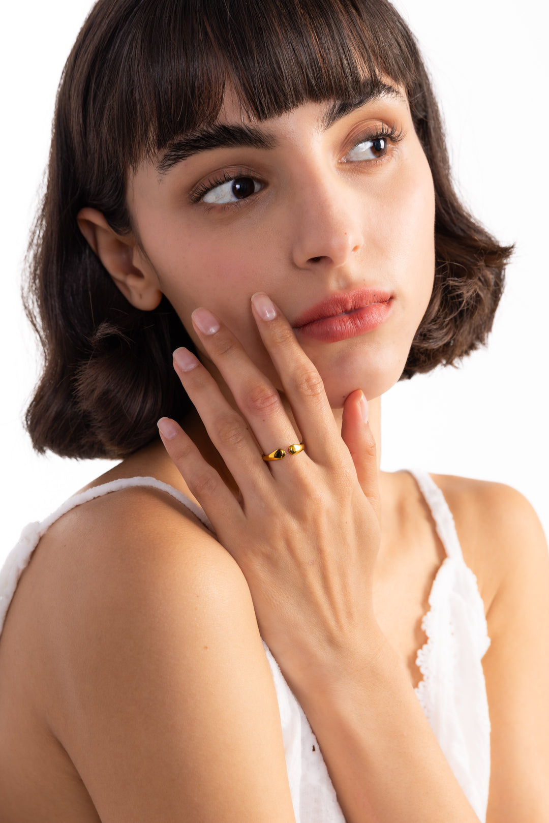 Amelina Ring – Edelstahl 18K vergoldet, Ring in organischer Tropfenform, frontal am Finger mit Hand am Hals getragen