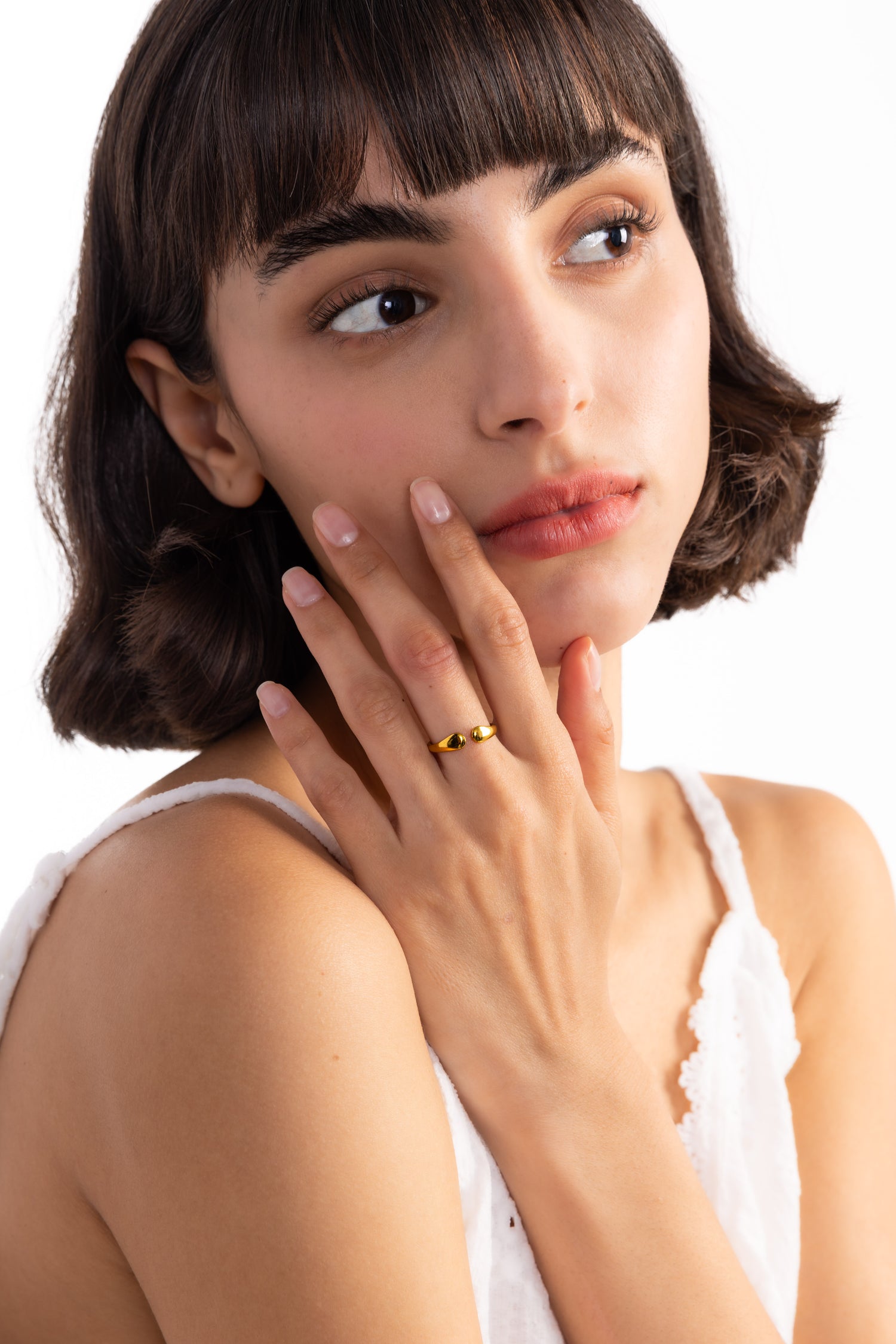 Amelina Ring – Edelstahl 18K vergoldet, Ring in organischer Tropfenform, frontal am Finger mit Hand am Hals getragen