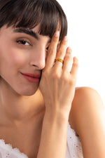 Damen-Ring Elanira – Edelstahl 18K vergoldet, mehrreihiger Crossover-Ring, am Finger getragen mit Hand an Wange