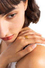 Kelana Ring – Edelstahl 18K vergoldet, breiter mehrreihiger Ring, am Finger getragen mit Hand auf Schulter und Blick nach unten