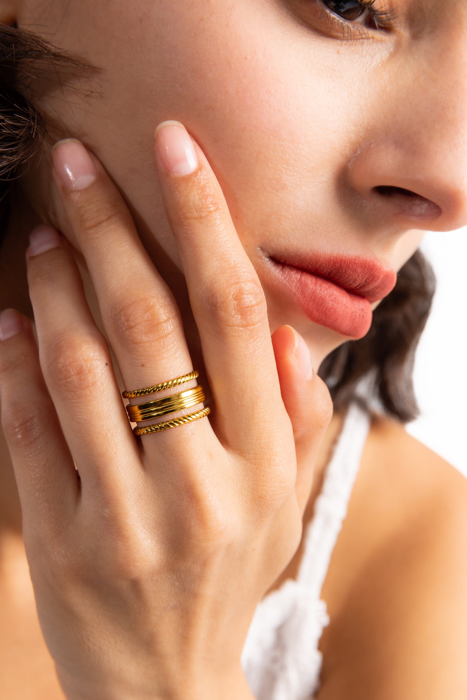 Damen-Ring Nirella von Mercy’s Jewelry – Edelstahl 18K vergoldet, breiter mehrreihiger Ring mit Rillen-Design, Nahaufnahme am Gesicht getragen