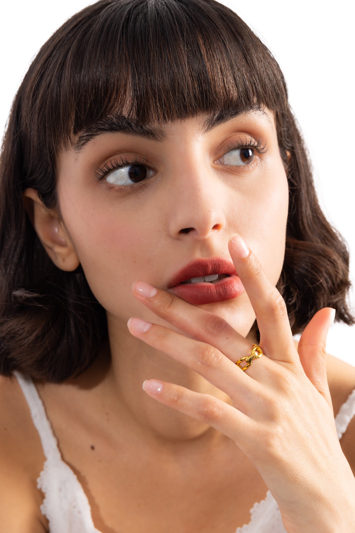 Damen-Ring Talira – Edelstahl 18K vergoldet, Kettenring mit Gliederstruktur, am Finger getragen mit Hand an Lippen