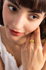 Valina Ring – Edelstahl 18K vergoldet, Statement-Ring mit Symbol-Design, seitlich am Finger getragen mit Hand an Wange
