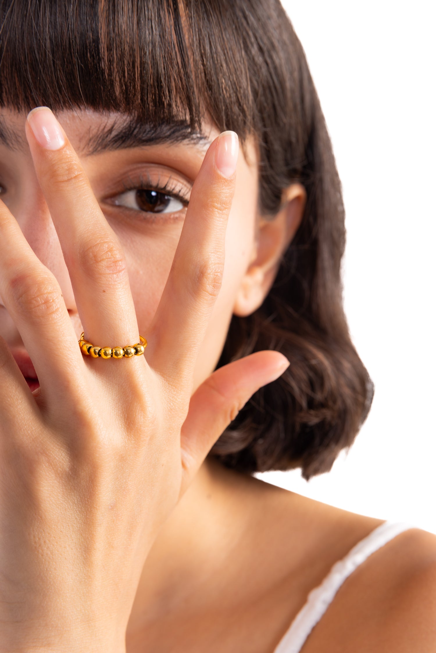 Damen-Ring Yariel von Mercy’s Jewelry – Edelstahl 18K vergoldet, Ring mit Kugelstruktur, Nahaufnahme am Finger mit Hand vors Gesicht