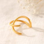 Minimalistischer Earcuff mit offenem Design aus Edelstahl 18 K vergoldet, liegt auf hellem Stoff mit sanftem Licht und Trockenblumen im Hintergrund – Nuvin Earcuff | Mercy’s Jewelry