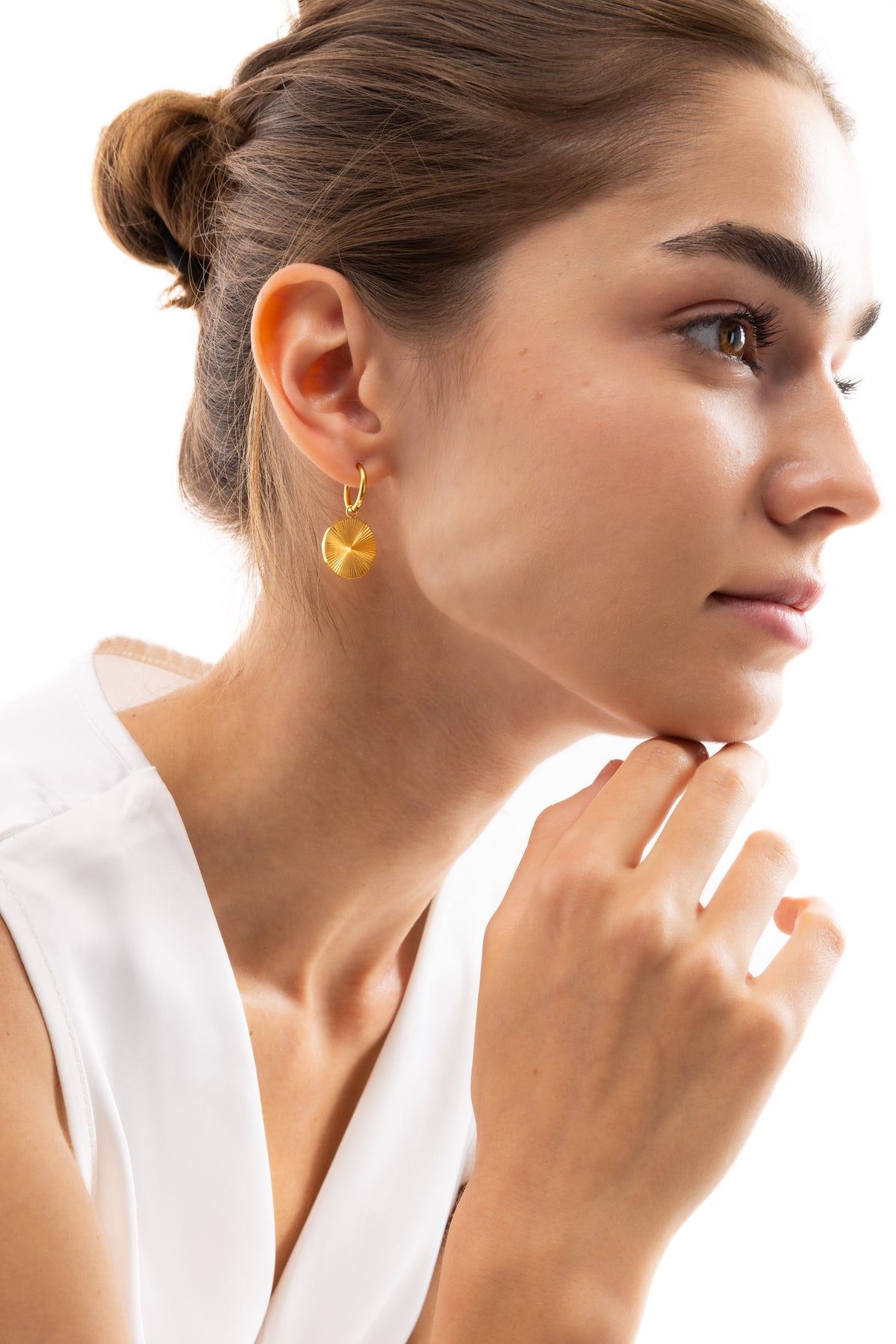Elira Huggies Ohrringe, goldene Huggies mit Sonnenmotiv-Anhänger, seitliche Ansicht am Ohr, Edelstahl 18K vergoldet