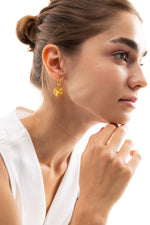 Elira Huggies Ohrringe, goldene Huggies mit Sonnenmotiv-Anhänger, seitliche Ansicht am Ohr, Edelstahl 18K vergoldet
