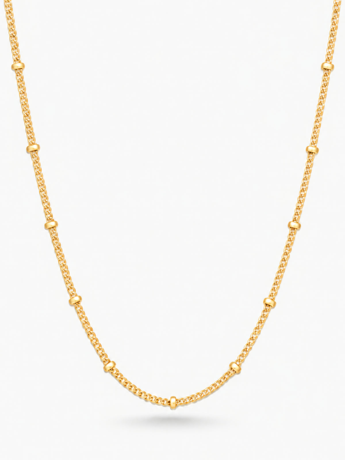 Enira Halskette von Mercy’s Jewelry mit kleinen goldfarbenen Kugeln auf feiner Panzerkette vor weißem Hintergrund.