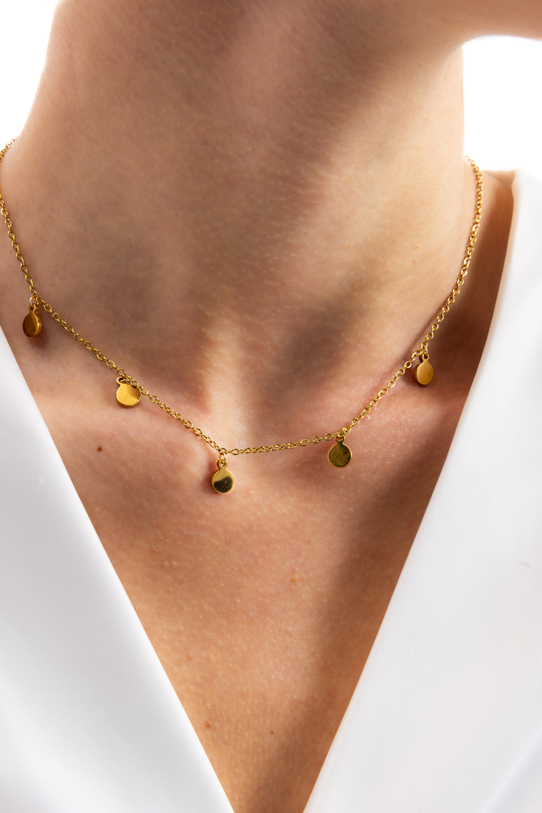 Kaira Kette von Mercy’s Jewelry – Edelstahl 18K vergoldet, feine Plättchen-Kette mit goldenen Anhängern, Nahaufnahme am Hals getragen