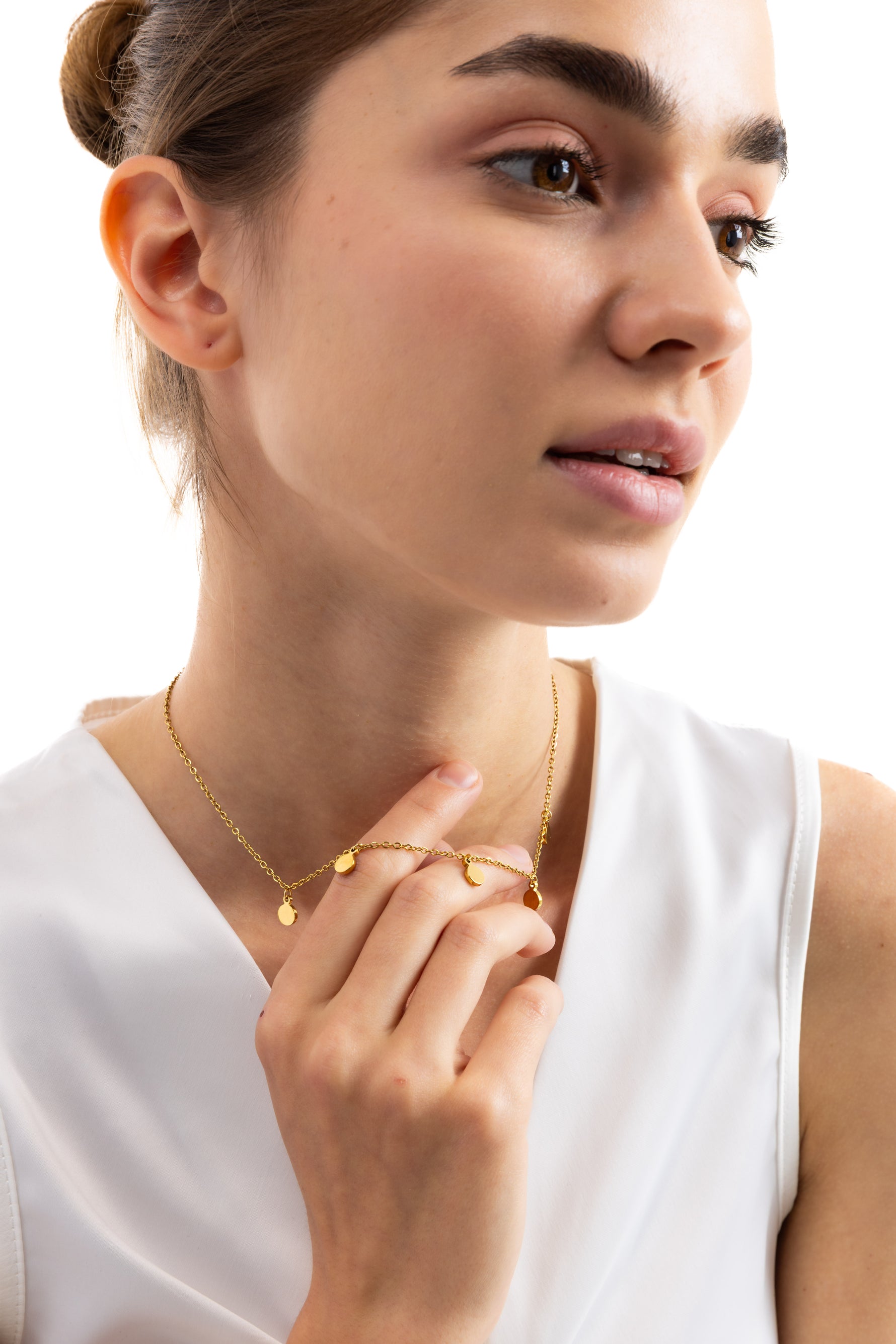Damen-Halskette Kaira – Edelstahl 18K vergoldet, Plättchen-Kette mit goldenen Anhängern, seitlich getragen, Hand am Hals