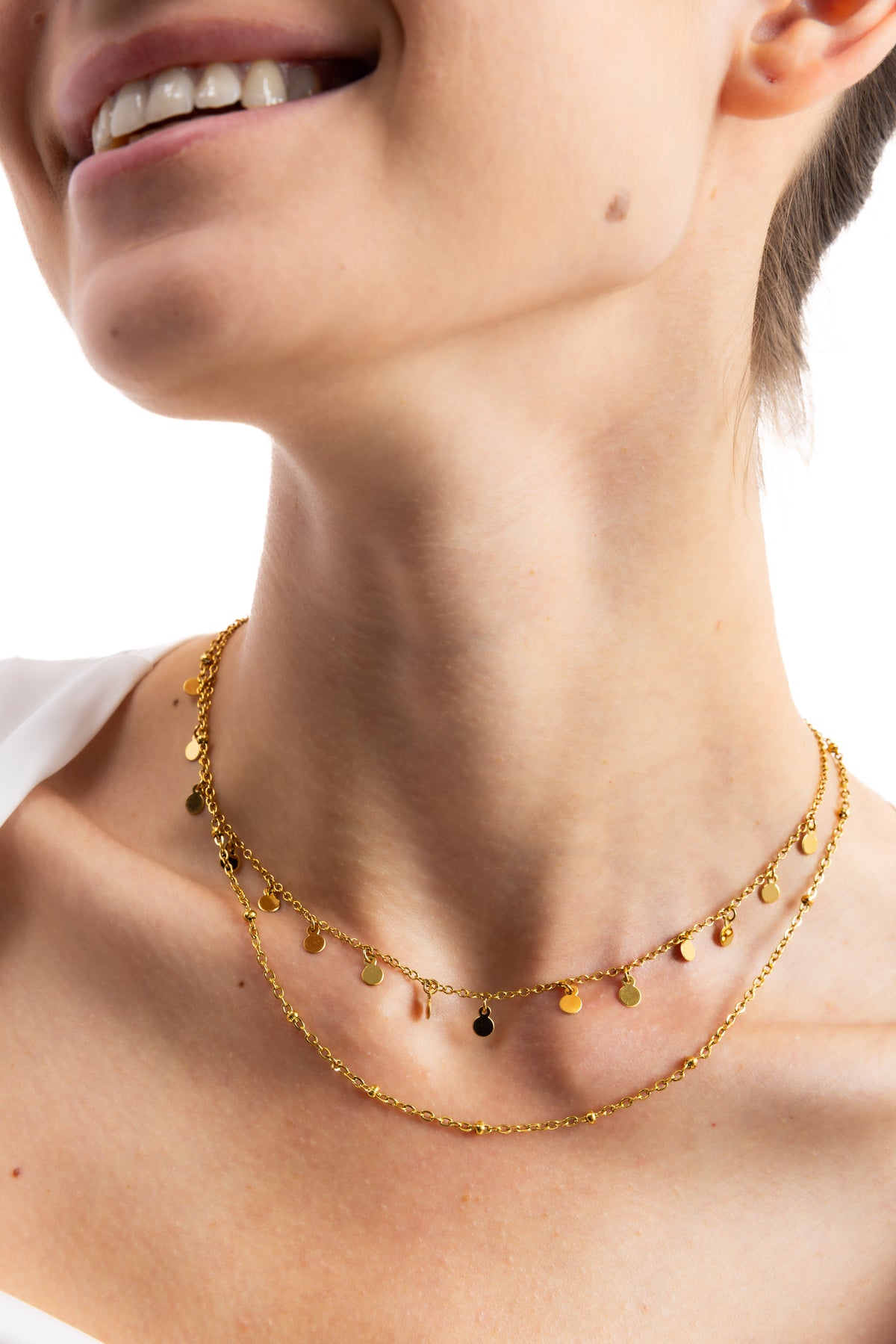 Naia Layers Kette – Edelstahl 18K vergoldet, zweireihige Layering-Kette mit Plättchen und Mini-Knoten, Detailaufnahme am Hals