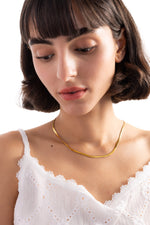 Velira Halskette – Edelstahl 18K vergoldet, Sleek-Snake-Kette in glatter Form, frontal am Hals getragen, Blick nach unten