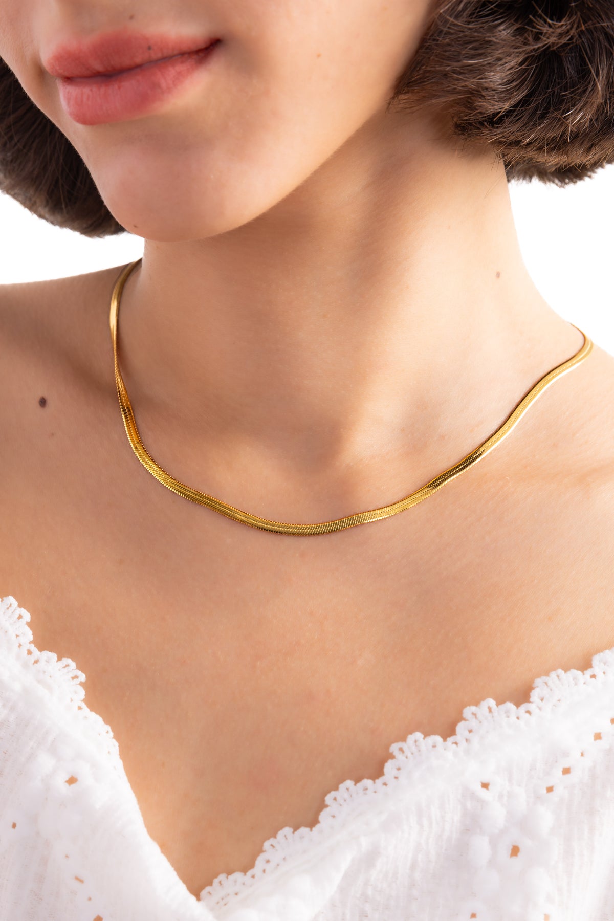 Damen-Halskette Velira – Edelstahl 18K vergoldet, Sleek-Snake-Kette, Nahaufnahme am Dekolleté getragen, glatte Struktur