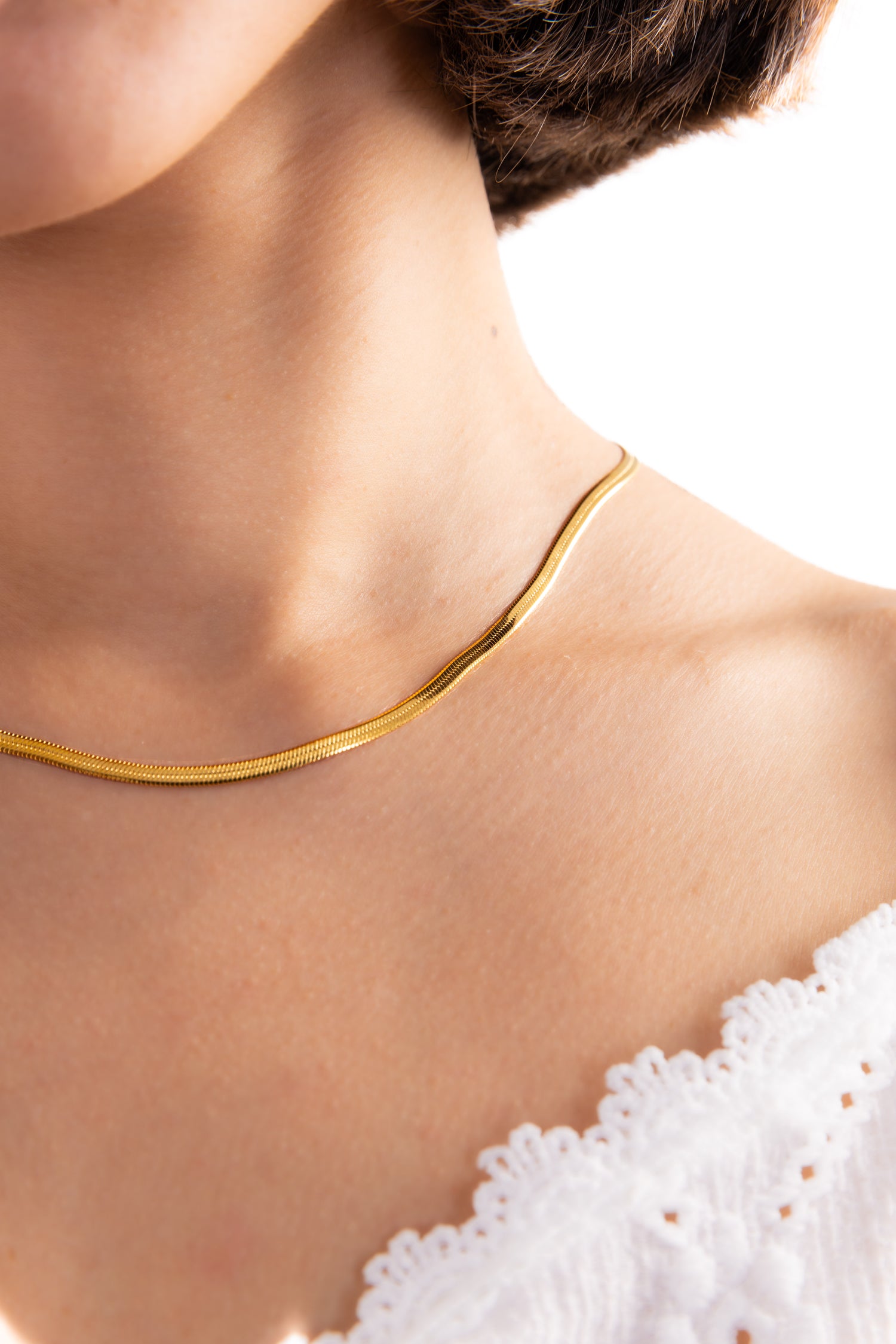 Damen-Halskette Velira – Edelstahl 18K vergoldet, Sleek-Snake-Kette in glatter Form, Nahaufnahme am Hals getragen