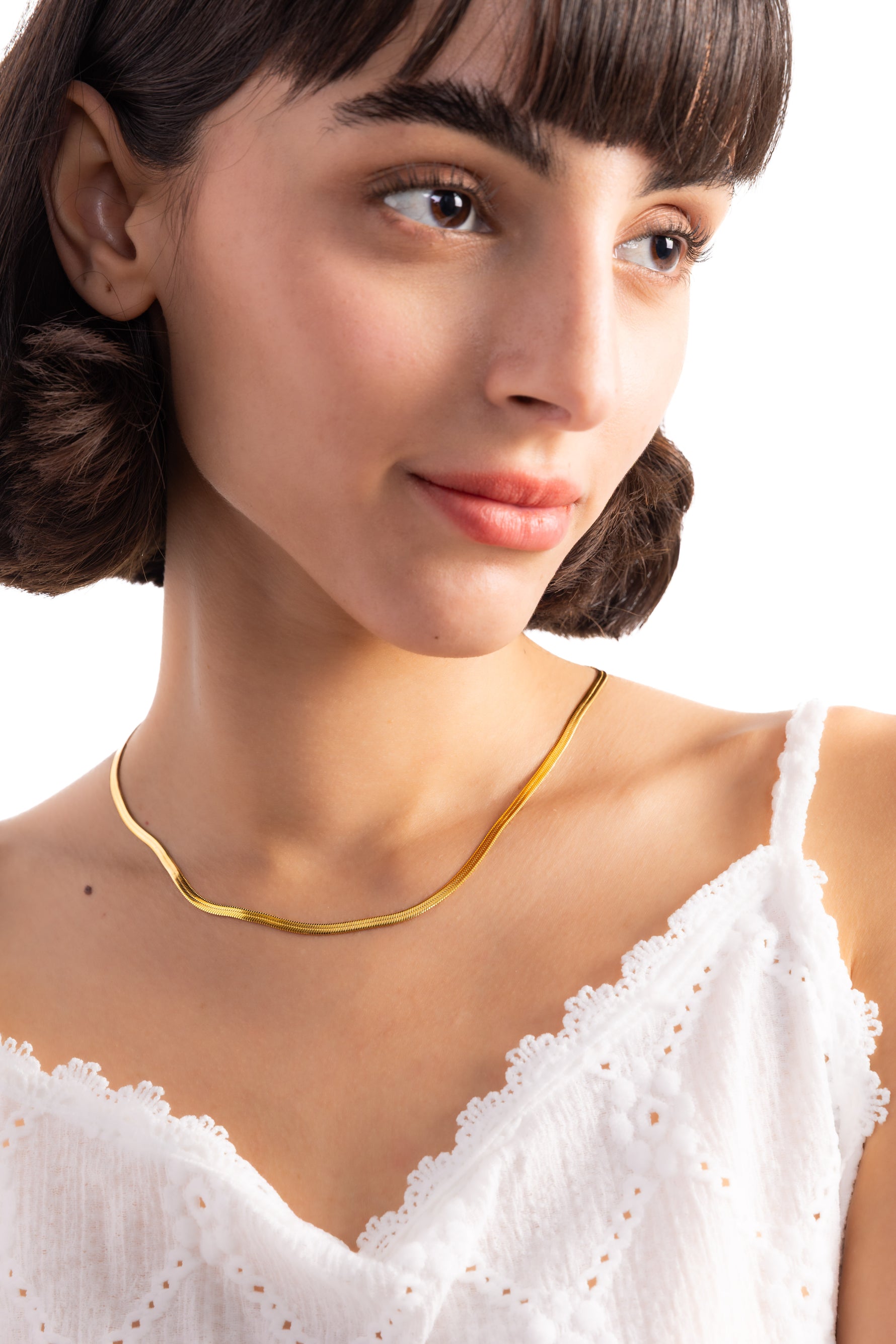 Velira Kette – Edelstahl 18K vergoldet, Sleek-Snake-Kette in glatter Form, seitlich am Hals getragen mit weißem Oberteil