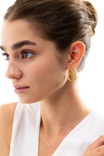 Orya Huggies Edelstahl 18K vergoldet – Portraitaufnahme am Modell, elegante Huggies mit strukturiertem runden Anhänger
