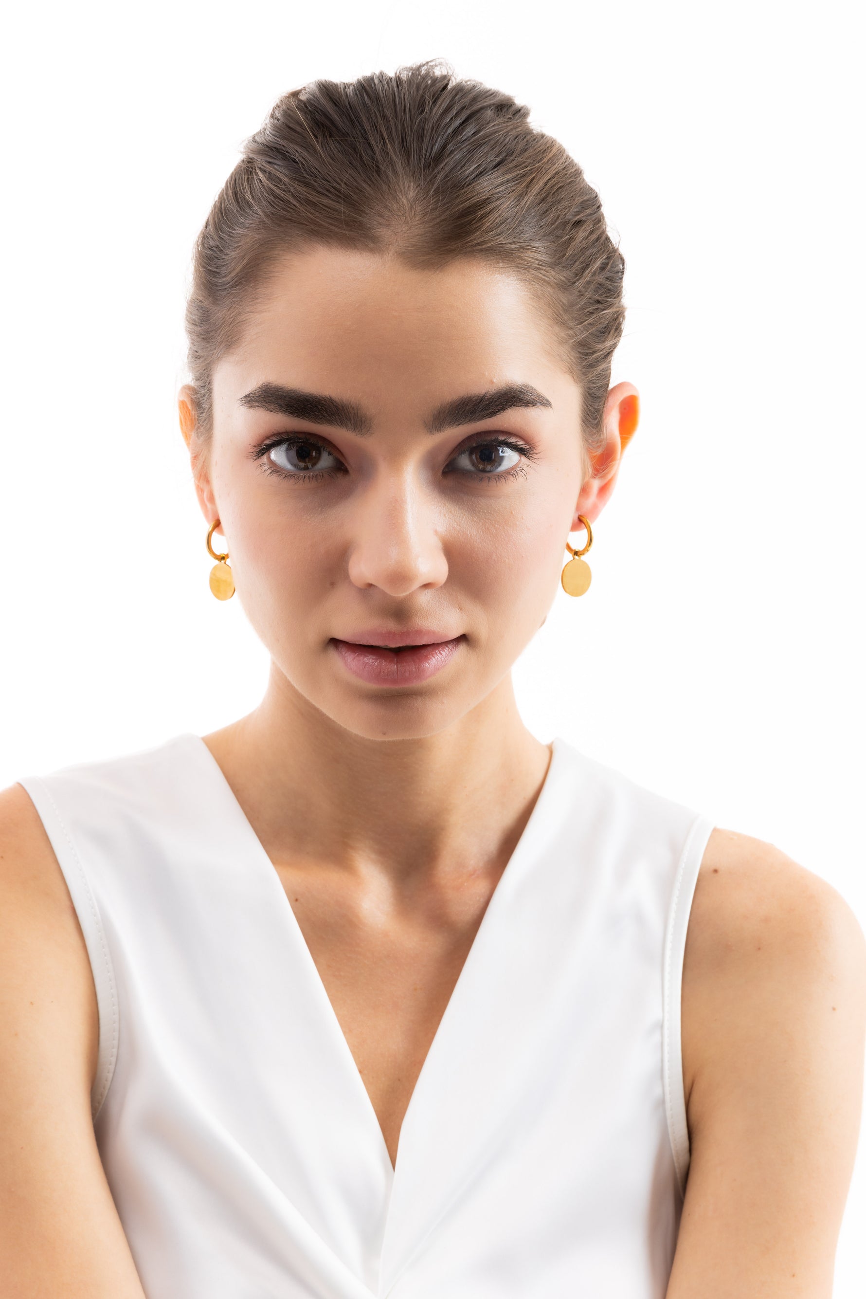 Frontalaufnahme des Models mit Isara Huggies Ohrringen, goldene Plättchen-Anhänger, hochwertiger Edelstahl 18K vergoldet