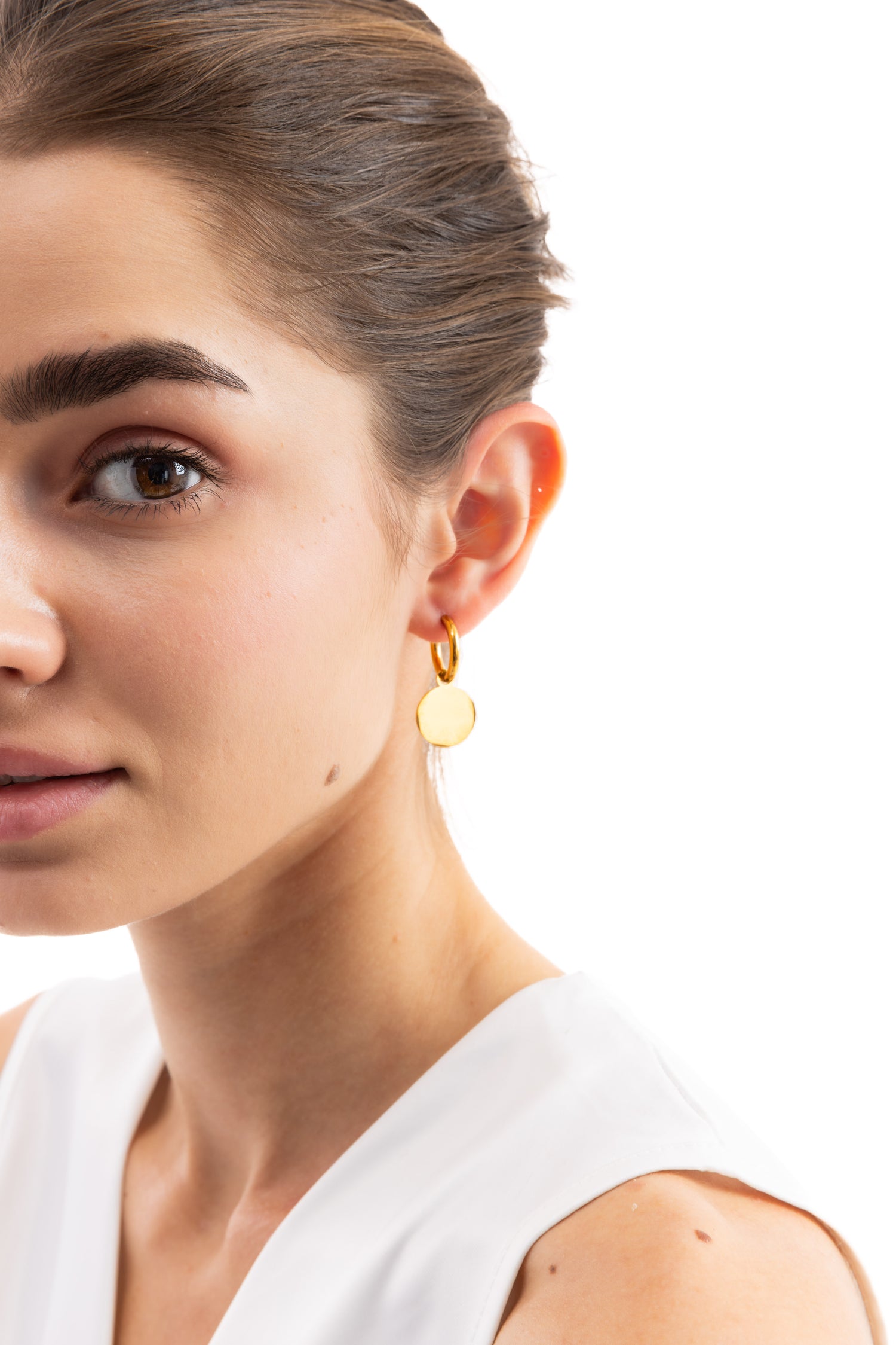 Mercy’s Jewelry Model in Seitenansicht trägt Isara Huggies Ohrringe mit goldenen Plättchen-Anhängern, Edelstahl 18K vergoldet