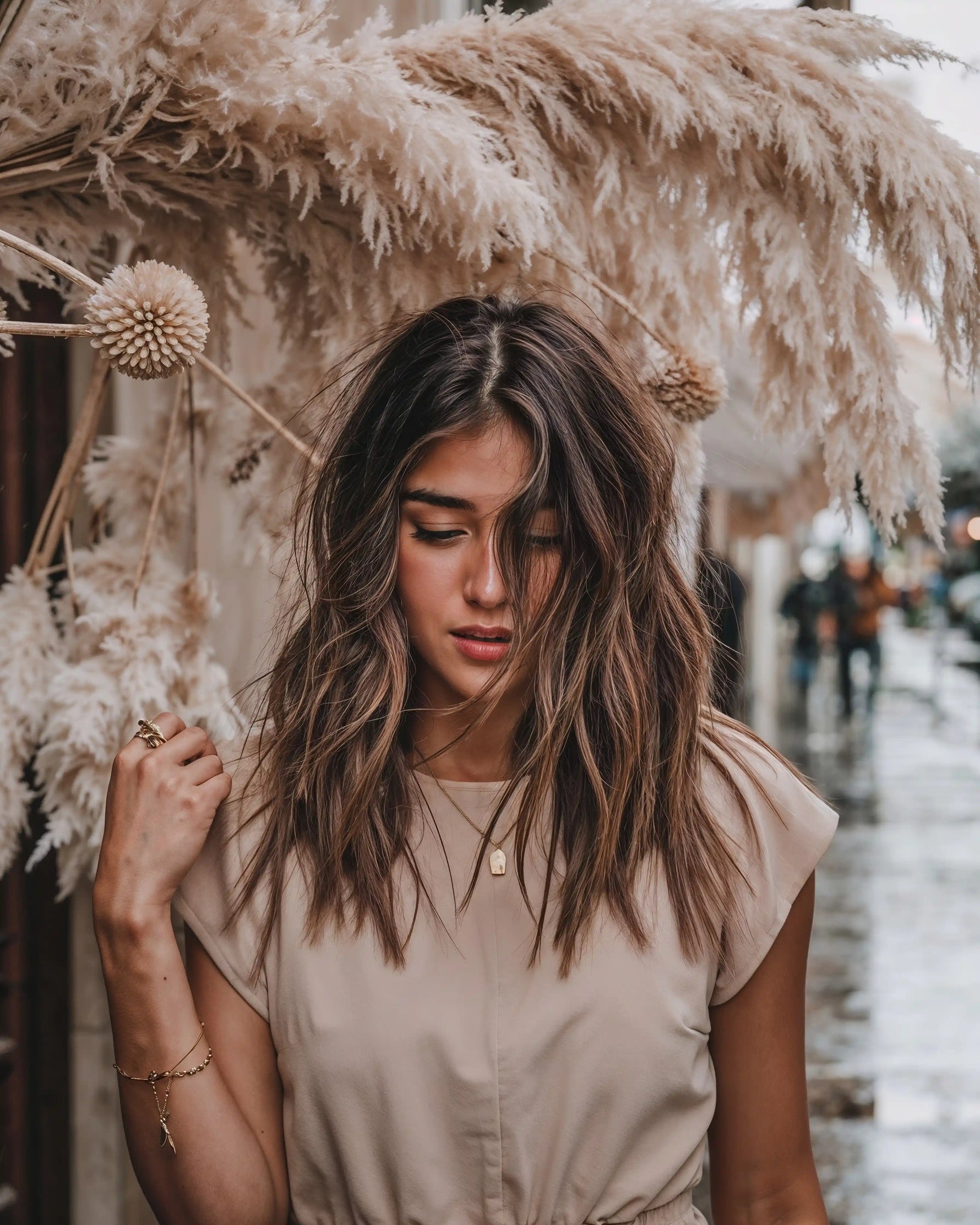 Model mit offenen Haaren trägt Mercy’s Jewelry Schmuck – goldene Halskette mit Anhänger, Armband und Ringe