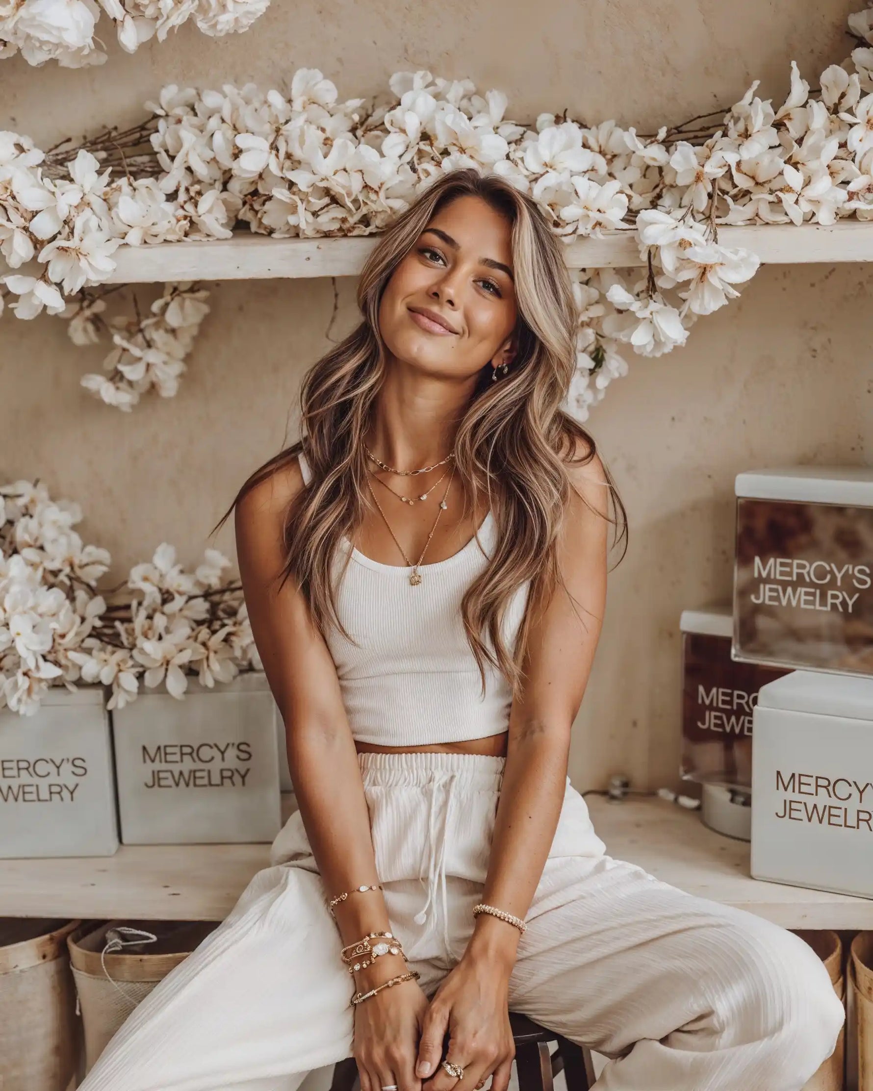 Model trägt Mercy’s Jewelry Schmuck – goldene Halsketten, Armbänder und Ohrringe