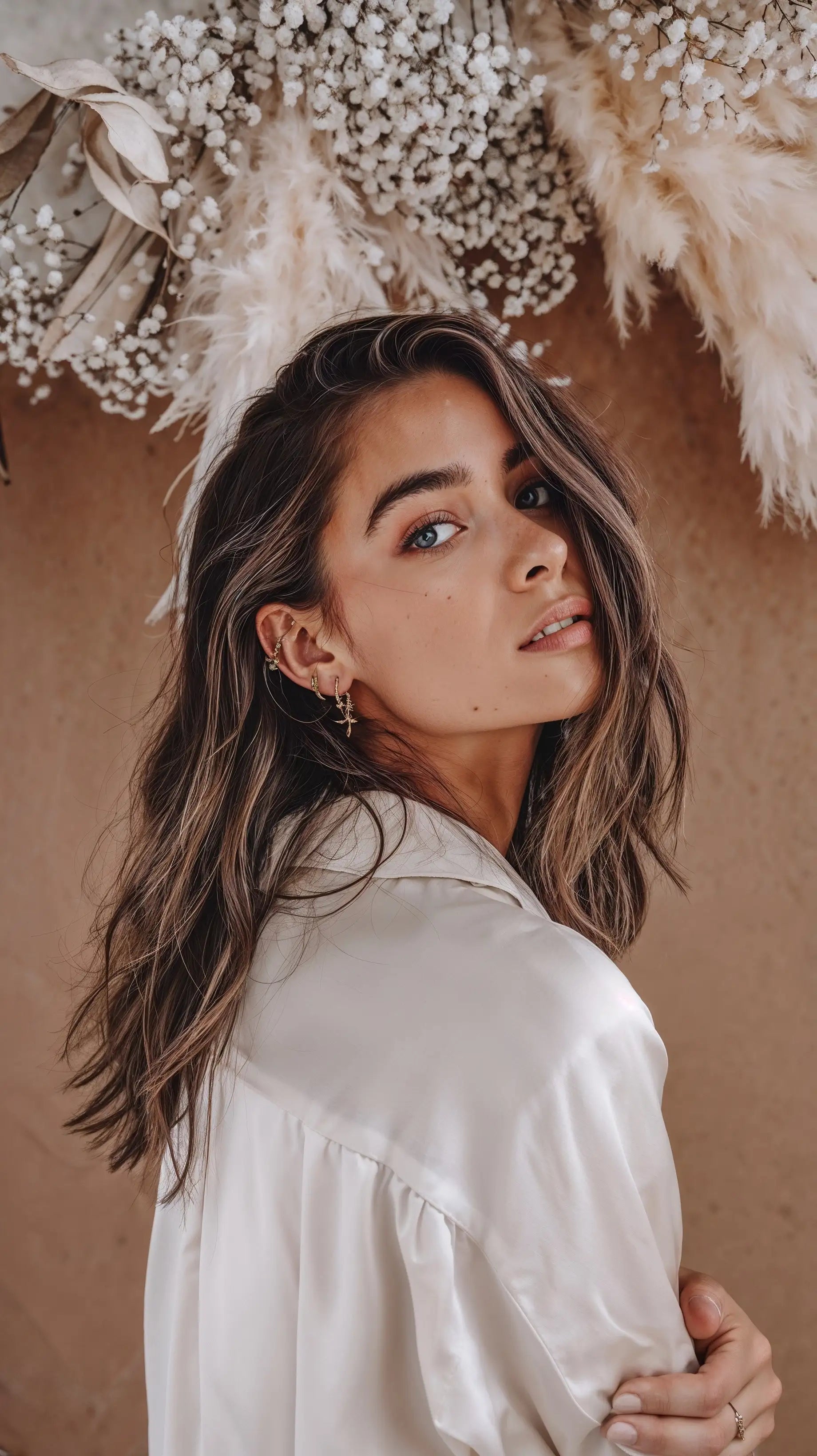 Model trägt mehrere goldene Ohrringe von Mercy’s Jewelry im modernen Layering-Look