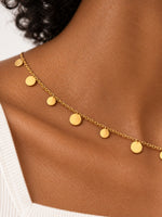 Detailaufnahme der Lyra Goldkette mit glatten, runden Plättchen und feinen ovalen Kettengliedern.