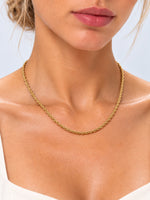 Goldfarbene Kordelkette Tharien am Hals eines Models, frontal mit sichtbarem Kettenverlauf am Dekolleté.