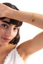 Noelia Armband Perlen aus Edelstahl 18K vergoldet, Modell hebt den Arm, das Armband liegt elegant am Handgelenk