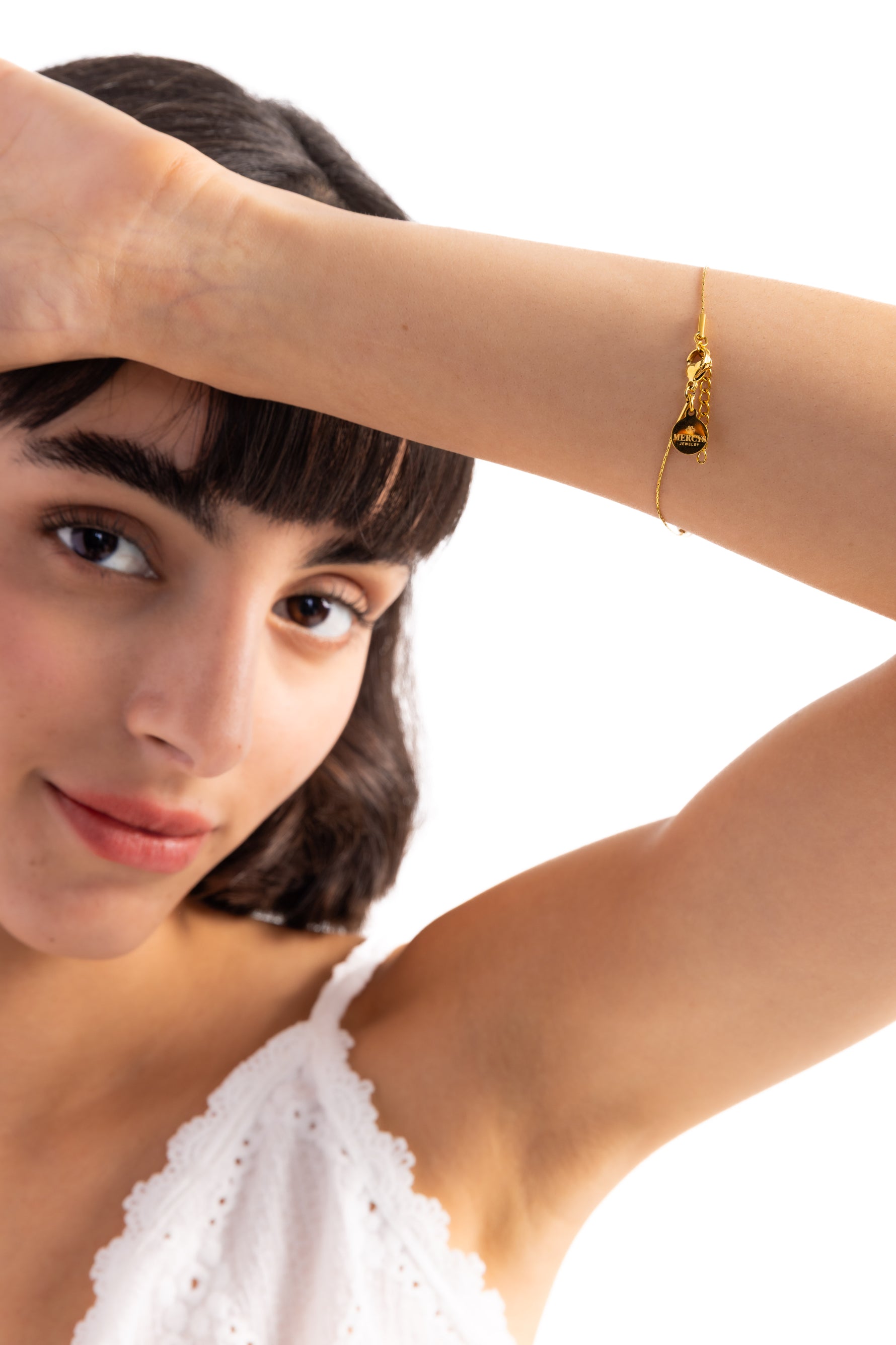 Noelia Armband Perlen aus Edelstahl 18K vergoldet, Modell hebt den Arm, das Armband liegt elegant am Handgelenk