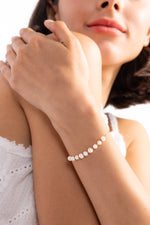 Noelia Armband mit Perlen aus Edelstahl 18K vergoldet, Modell verschränkt die Hände und zeigt das Armband dezent