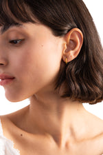 Avenil Huggies Edelstahl 18K vergoldet – Portraitaufnahme am Modell, strukturierte goldene Twist-Huggies für eleganten Look
