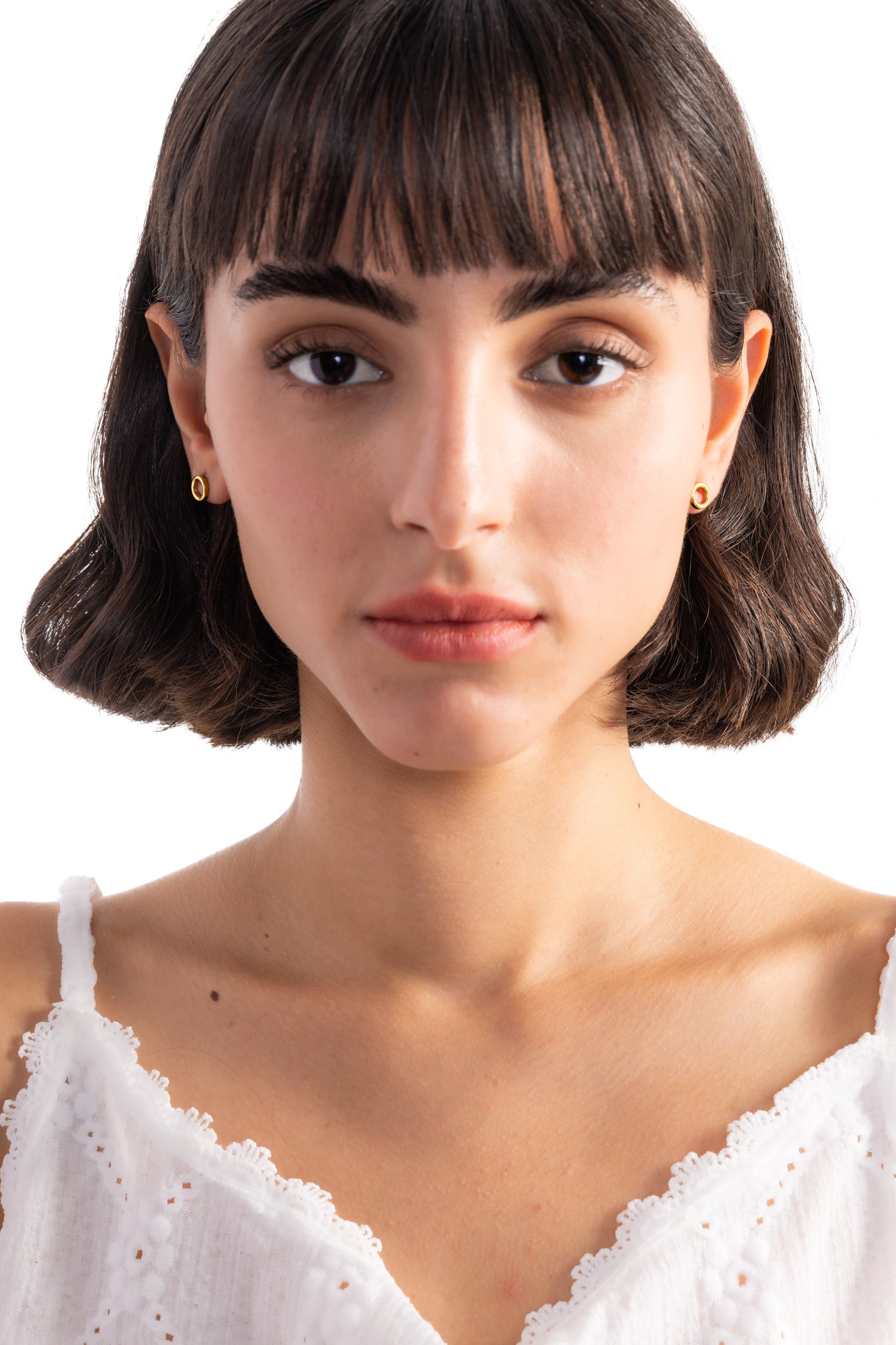 Enoa Studs Edelstahl 18K vergoldet – frontale Aufnahme am Modell, schlichte goldene Ohrstecker in minimalistischer Kreisform