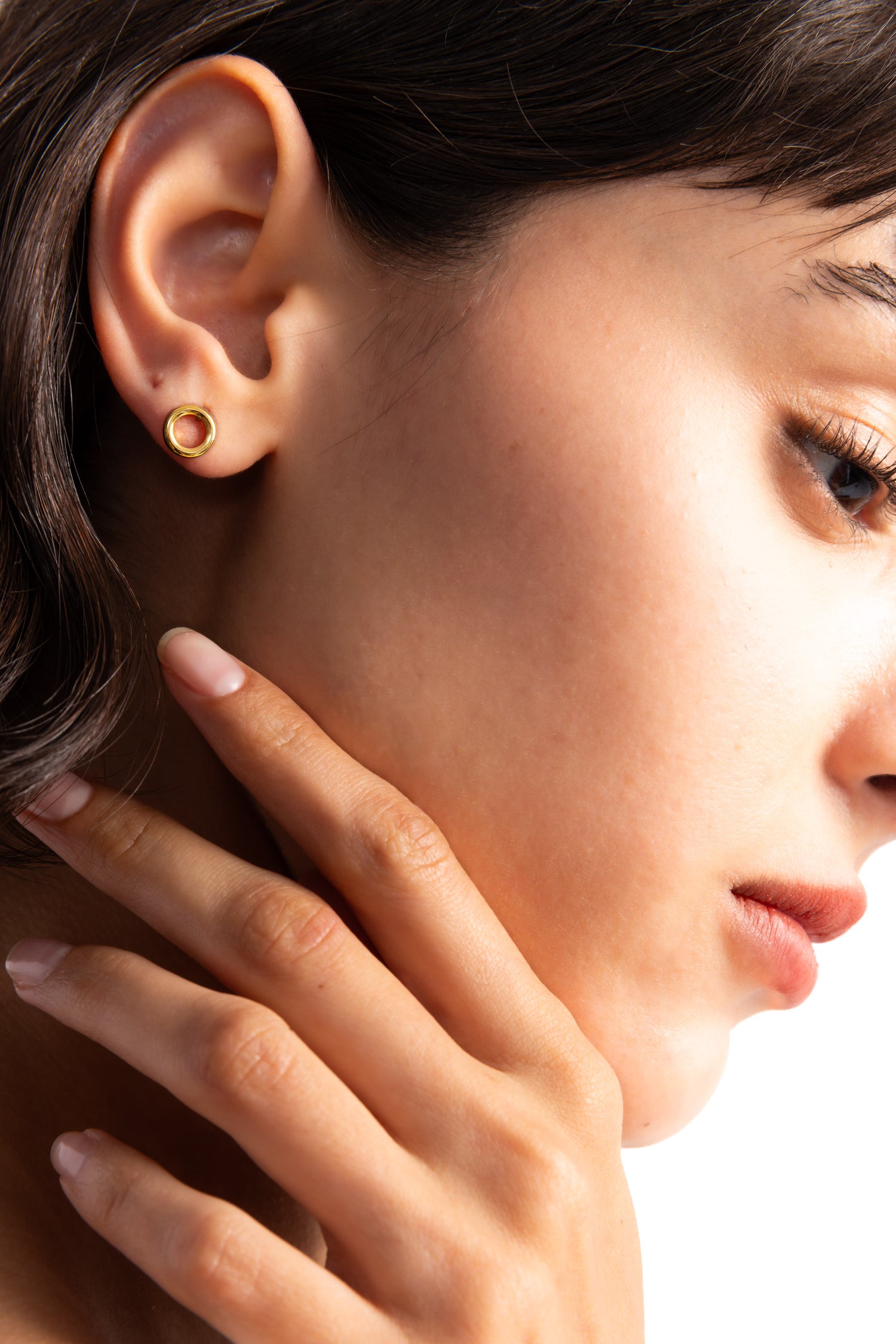 Enoa Studs Edelstahl 18K vergoldet von Mercy’s Jewelry – Nahaufnahme am Ohr getragen, kleine goldene Ohrstecker in runder Kreisform
