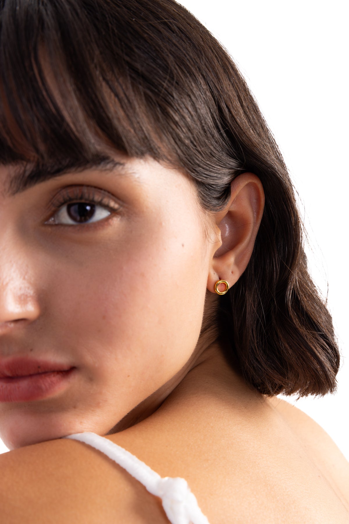 Enoa Studs Edelstahl 18K vergoldet – Portraitaufnahme am Modell, dezente goldene Ohrstecker in runder Form, schlicht und modern