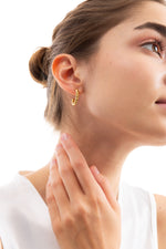 Rilani Kreolen Edelstahl 18K vergoldet – seitliche Ansicht am Ohr getragen, goldene Creolen im Rope-Twist Design