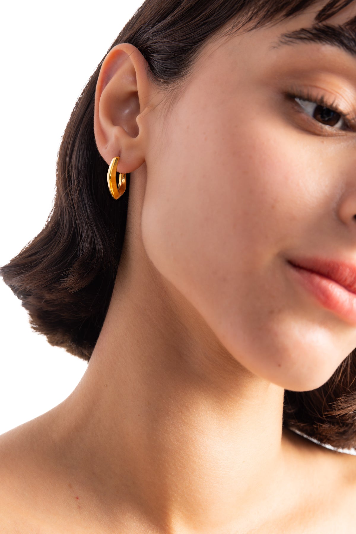 Virel Creolen Edelstahl 18K vergoldet – seitliche Ansicht am Ohr getragen, goldene Statement-Creolen mit modernem Design