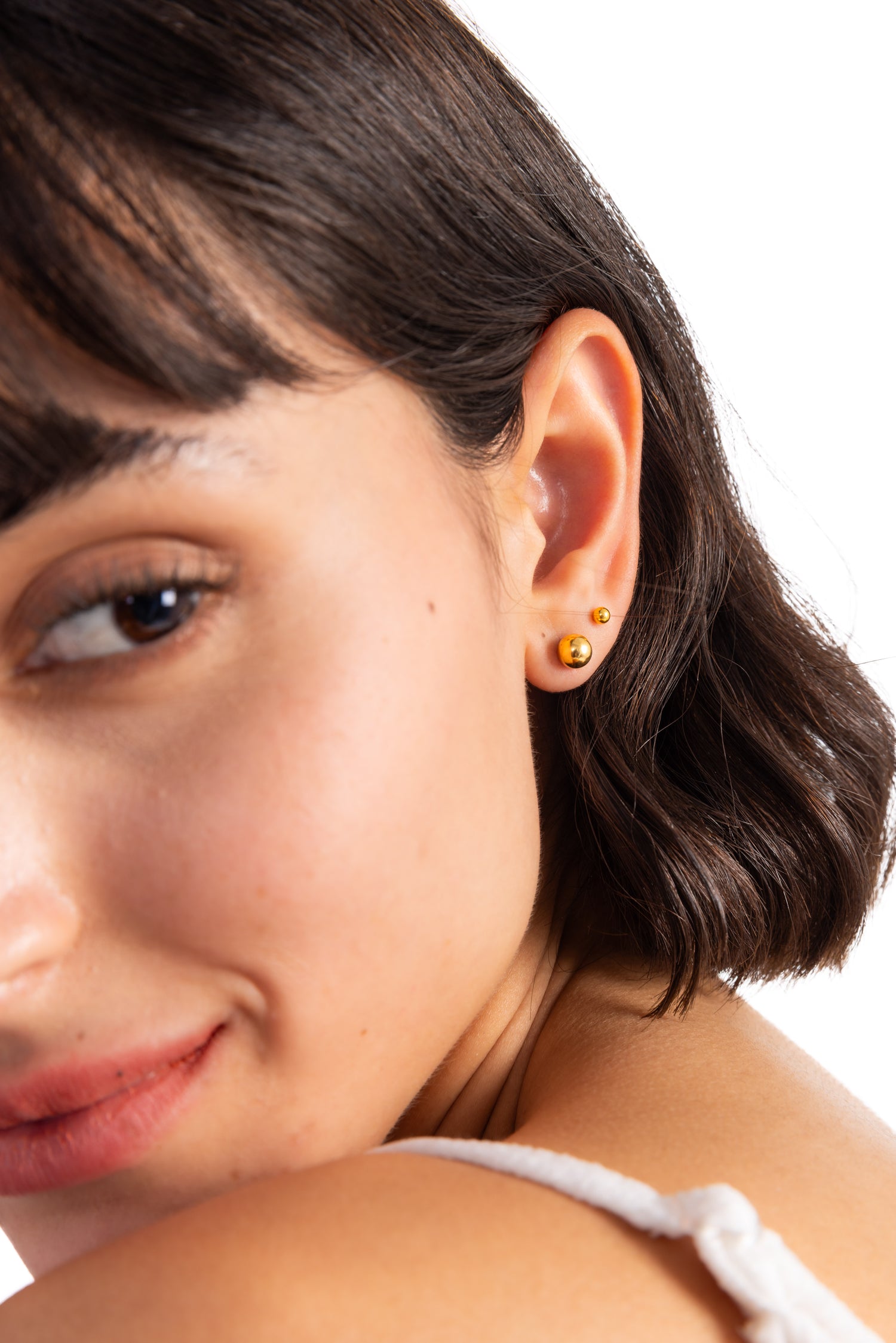 Mino Studs Ohrstecker Edelstahl 18K vergoldet von Mercy’s Jewelry – Nahaufnahme am Ohr, minimalistische Kugel-Ohrringe in Goldoptik
