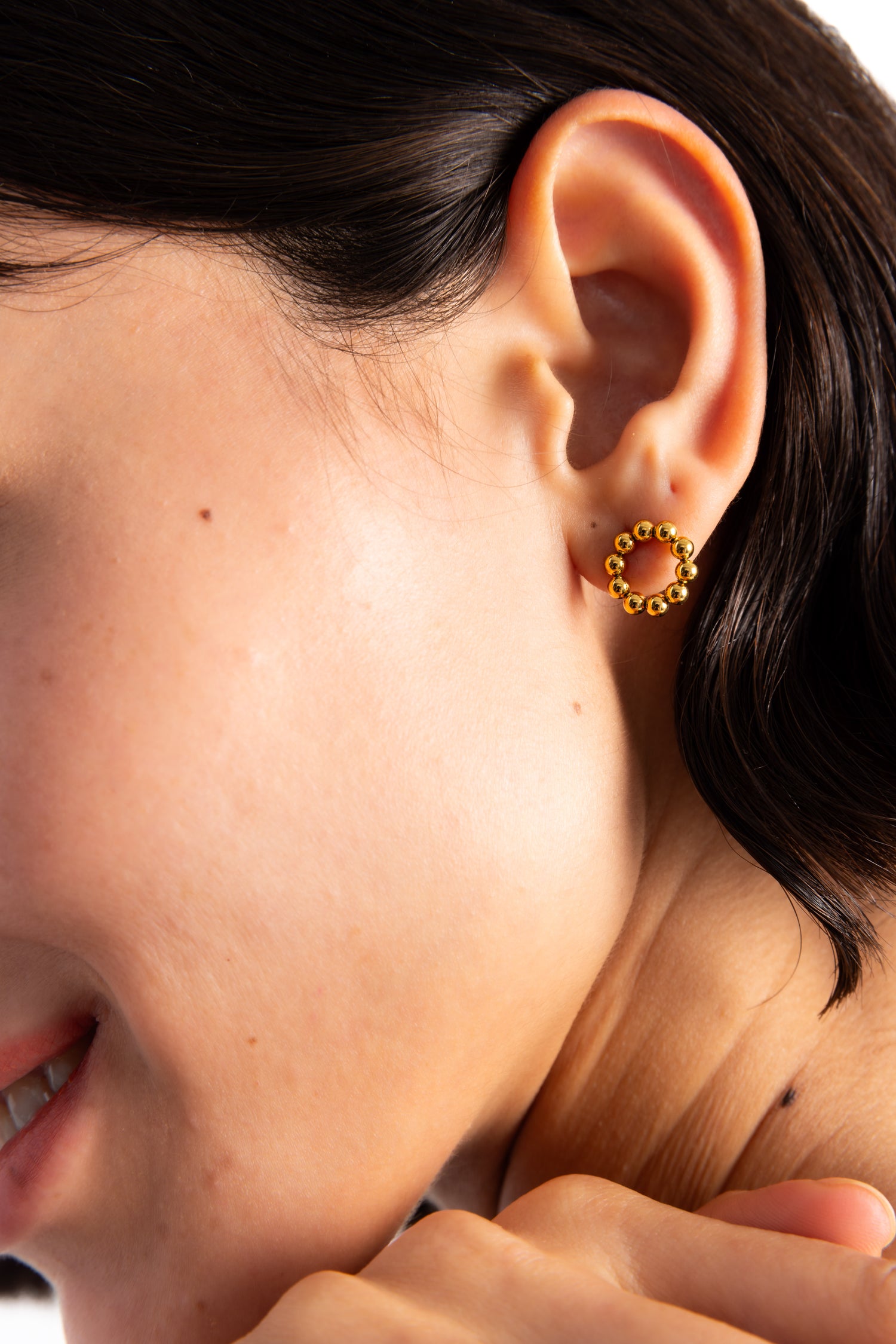 Orira Studs Ohrstecker Edelstahl 18K vergoldet von Mercy’s Jewelry – Nahaufnahme am Ohr, runde Form aus kleinen goldenen Kugeln