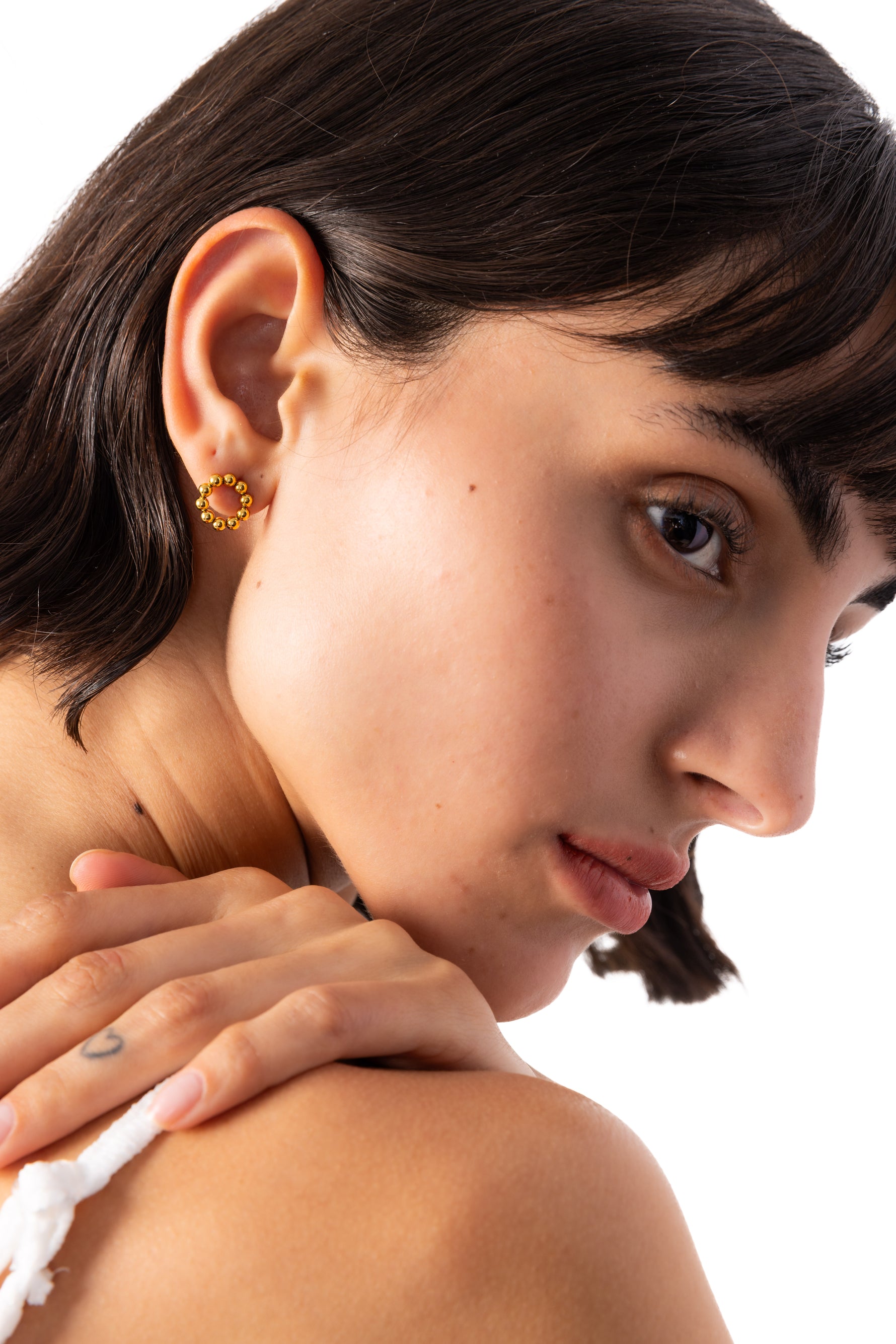 Orira Studs Ohrstecker Edelstahl 18K vergoldet – seitliche Ansicht am Ohr getragen, kleine goldene Kugeln formen einen Kreis
