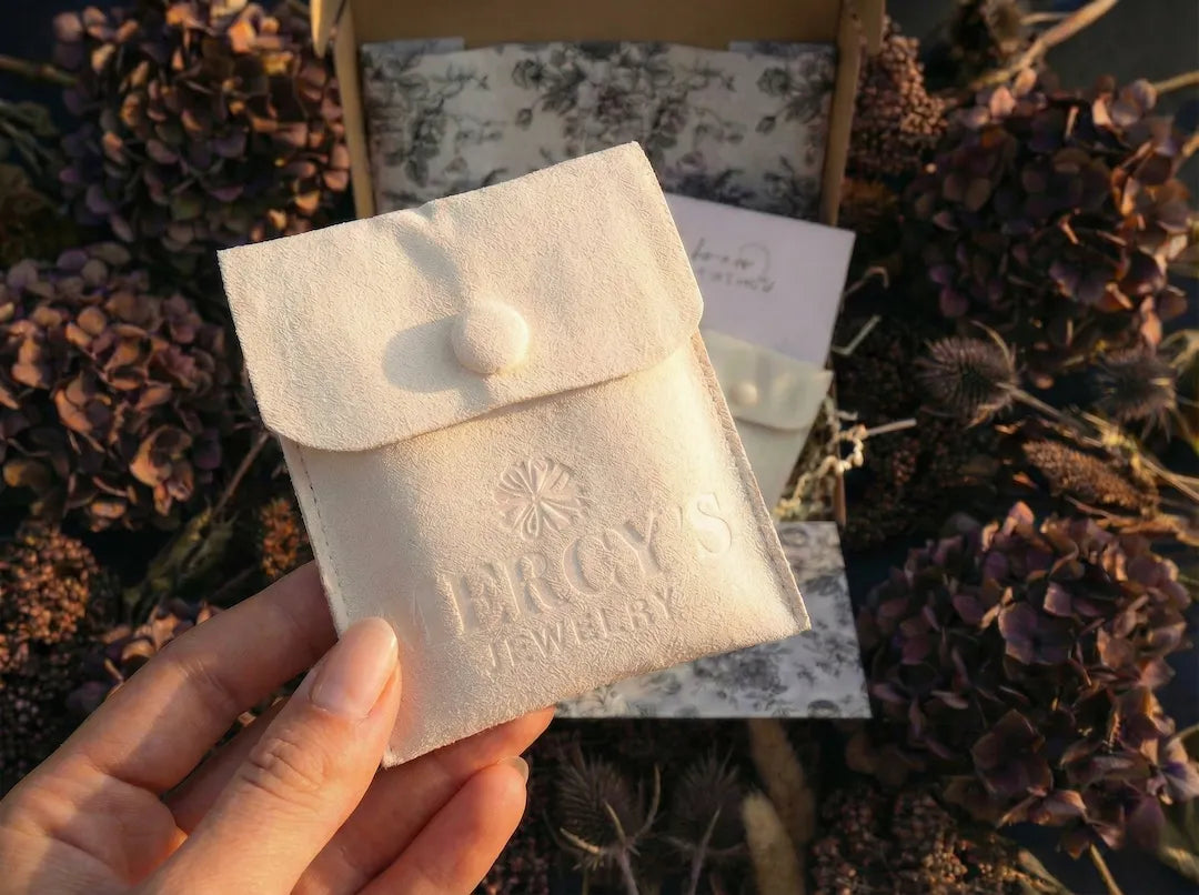 MERCY’S Jewelry Soft-Touch Pouch auf bymercy.de: Ein hochwertiger cremefarbener Samtbeutel für sicheren Schmuckversand.