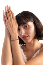 Talea Armband aus Titanium Steel 18K vergoldet, Frau trägt das Armband am Handgelenk, Hände sind elegant vor dem Gesicht gefaltet