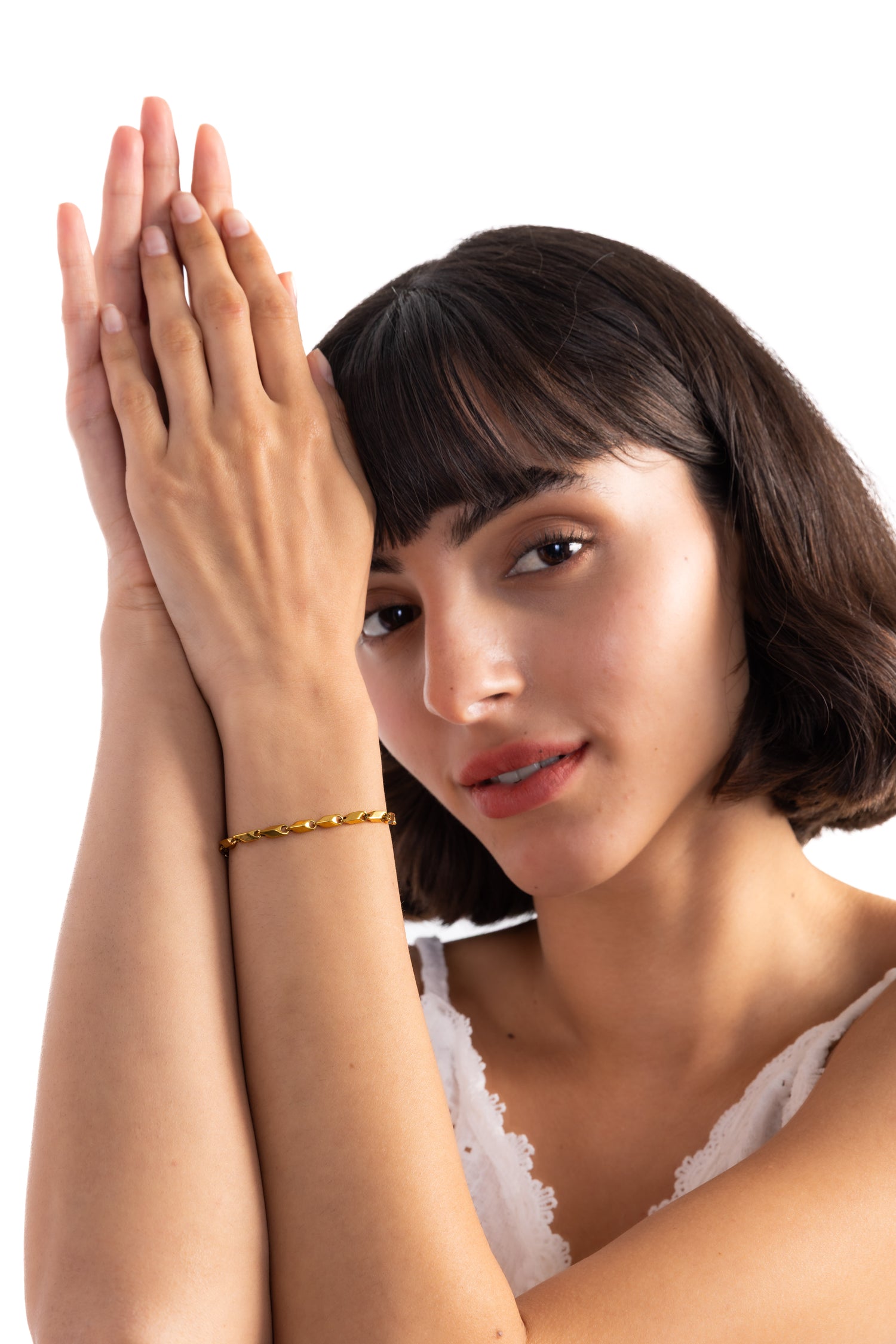 Talea Armband aus Titanium Steel 18K vergoldet, Frau trägt das Armband am Handgelenk, Hände sind elegant vor dem Gesicht gefaltet