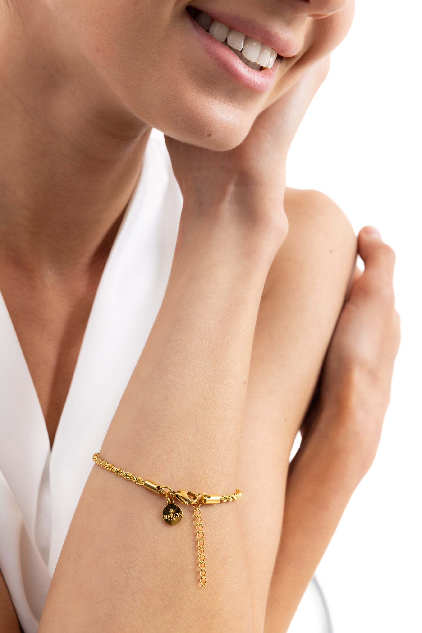 Tharien Armband mit gedrehter Rope-Struktur aus Edelstahl 18K vergoldet, am Handgelenk getragen, Modell lächelt