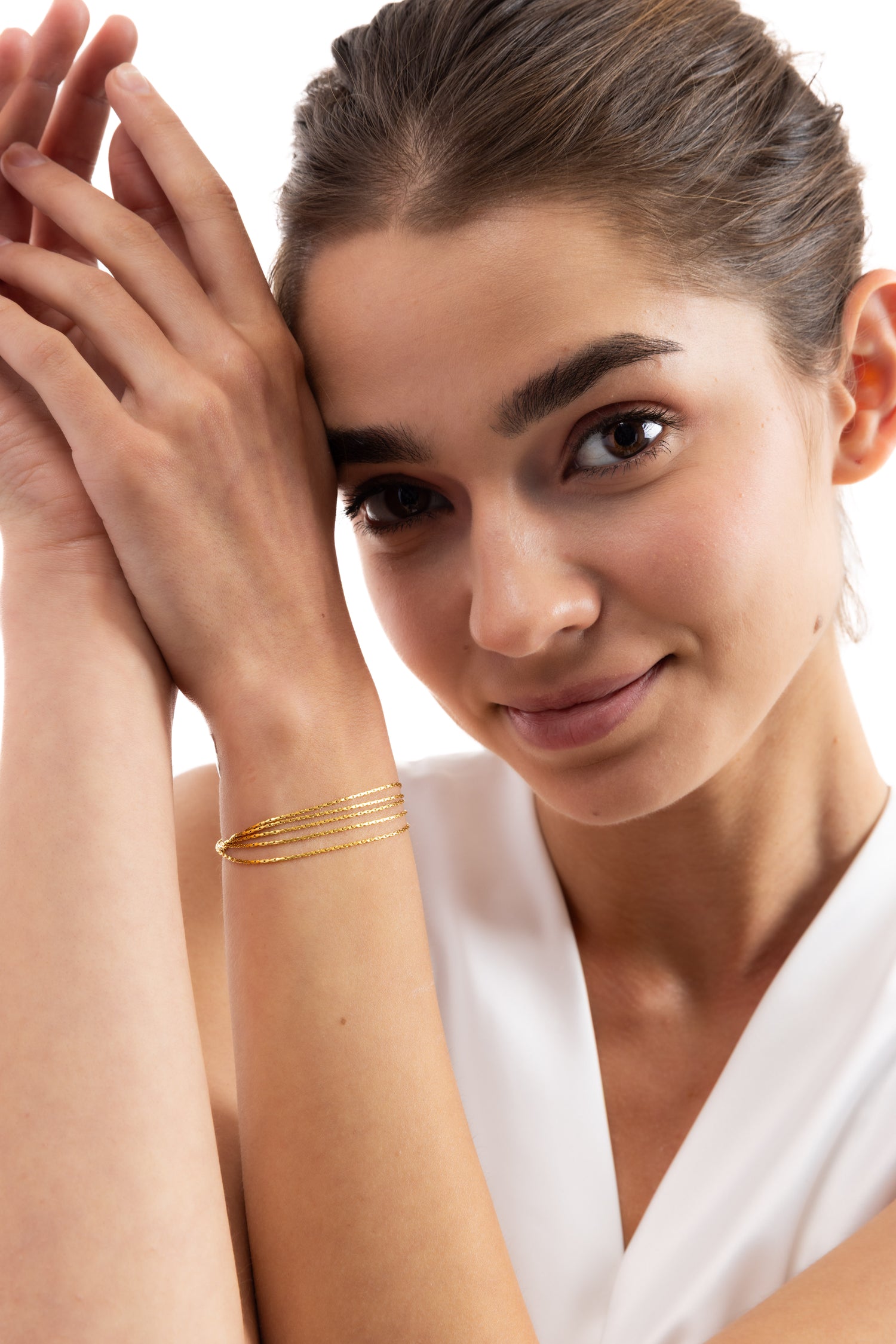 Modell trägt das Vianara Armband mehrsträngig aus Edelstahl 18K vergoldet in frontaler Ansicht