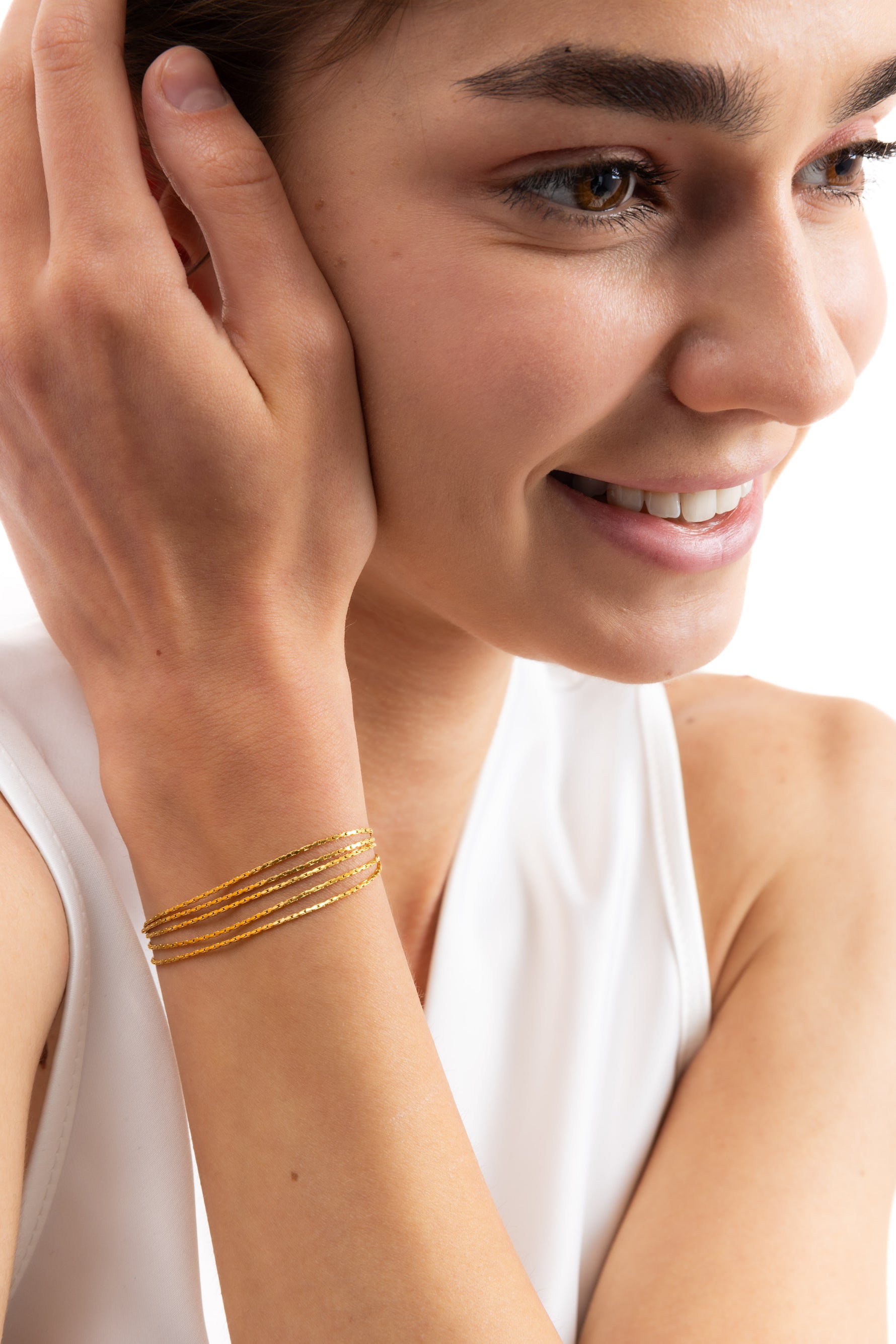 Vianara Armband mehrsträngig aus Edelstahl 18K vergoldet, am Handgelenk getragen, Modell lächelt